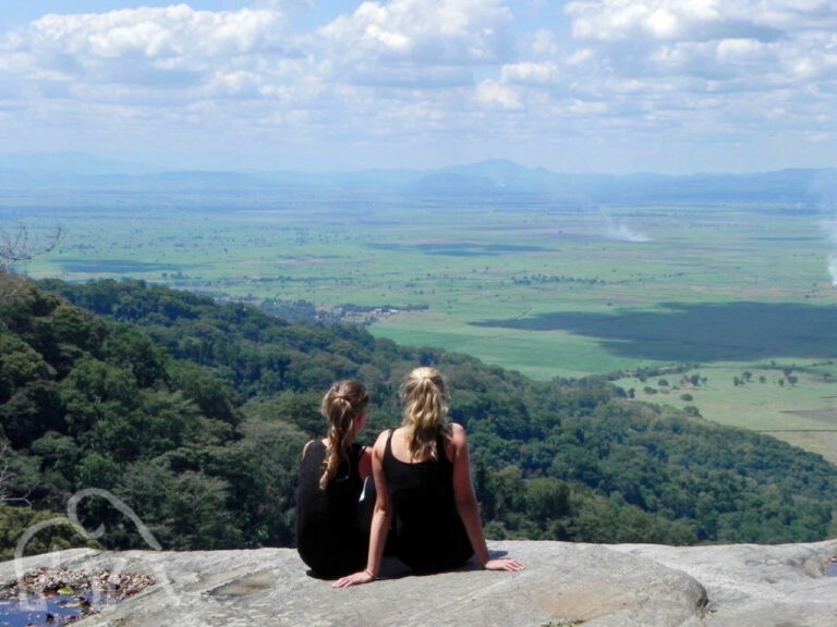 twee jonge meiden zittend op een rots uitkijkend over een vallei bij Udzungwa mountains