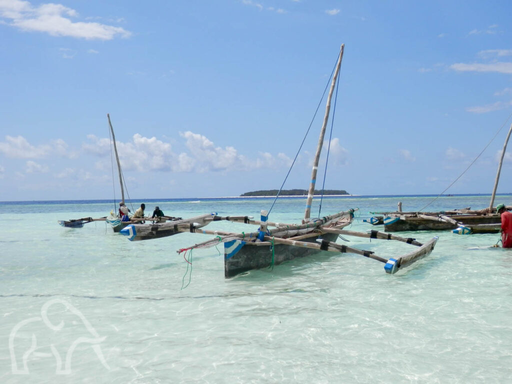 drie smalle vissersboten van hout met masten in de azuurblauwe zee van Zanzibar