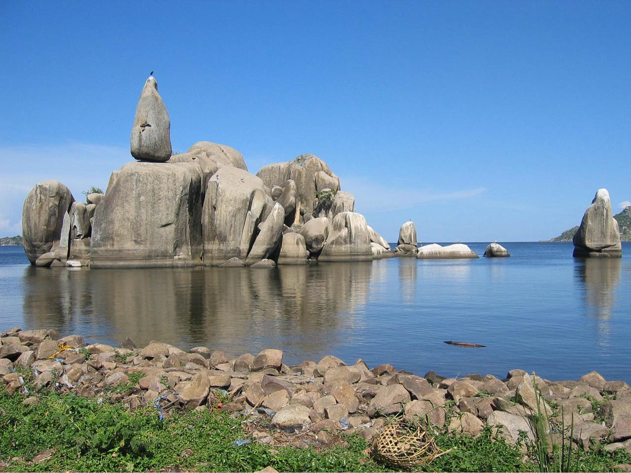 Lake Victoria in het water grote rotsblokken met daar bovenop een rotsblok in de vorm van een peer en een vogels on top dit wordt de bismarck rock