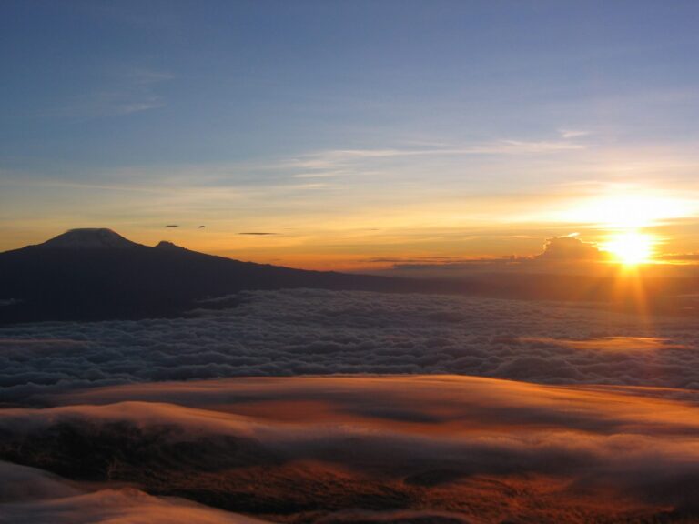 beklimming van mount meru met een opkomende zon boven de wolken op mount menu