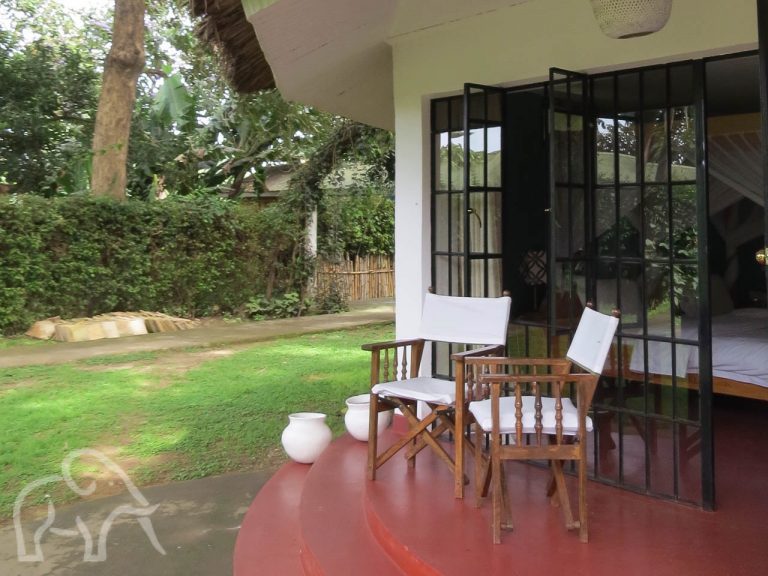 veranda met twee stoeltjes en uitzicht op de tuin bij Ilboru Safari lodge Arusha tanzania