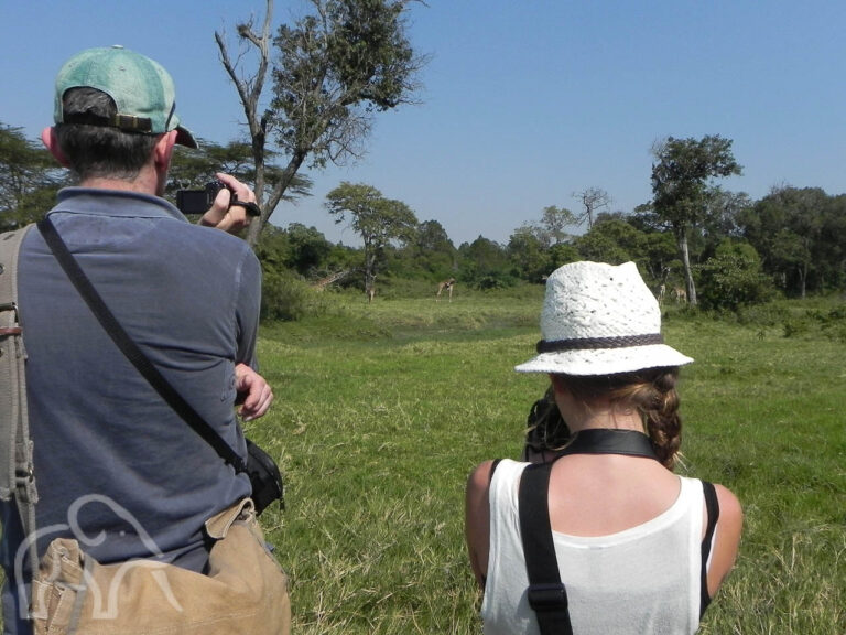 wandelsafari in tanzania met een man en jong meisje met camera's zijn dieren aan het spotten en fotograferen