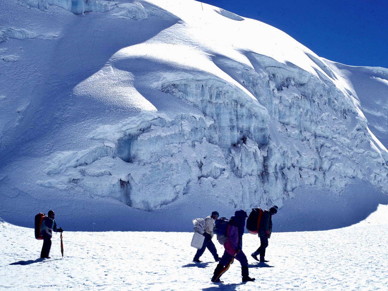Beklimming Kilimanjaro Tanzania. Mensen met dikke kleding op weg naar de top. Ze lopen door de sneeuw  en zijn bijna bij de top