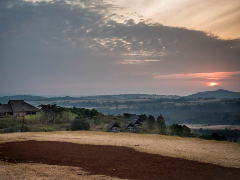 zonsondergang vanaf een heuvel uitkijkend op de lodge van rhotia valley tanzania