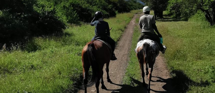 twee mensen op een paard tijdens een safari rondreis in mufindi highlands tanzania activiteit paardrijden