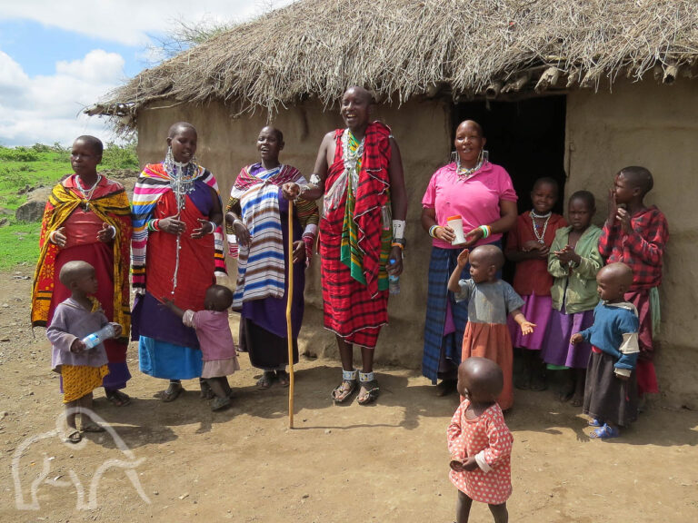 masai familie met ouders en kleine kinderen voor hun boma in de omgeving va de ngorongoro