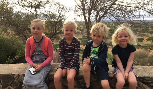Safari Tanzania rondreis met kinderen. Vier jongere kinderen op safari zittend op een muurtje 
