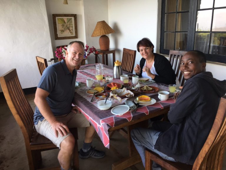 man en vrouw met gids aan het ontbijt bij simba farm kilimanjaro tanzania