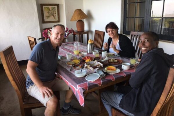 man en vrouw met gids aan het ontbijt bij simba farm kilimanjaro tanzania