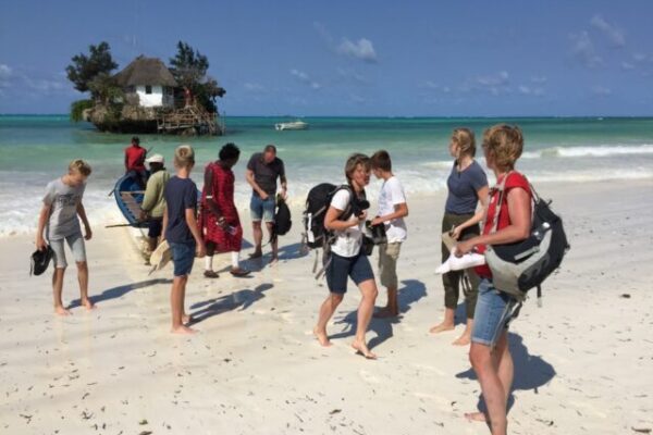 Familie safari en strandverblijf op Zanzibar. Meerdere gezinnen op het strand die net opgehaald zijn met het bootje van het restaurant the Rock.