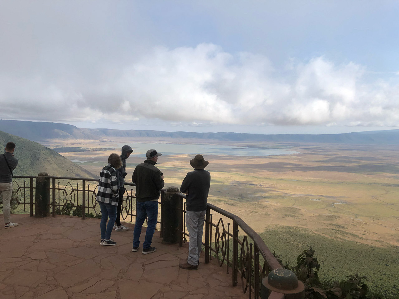 Safari Tanzania rondreizen ter inspiratie. Bij het uitzichtpunt van Ngororongoro krater kijken mensen en hun gids de Ngorongoro krater in. Een panoramisch uitzicht over de krater.