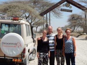 safari auto van droomreis tanzania met daarnaast een familie voor de ingang van de serengeti tanzania