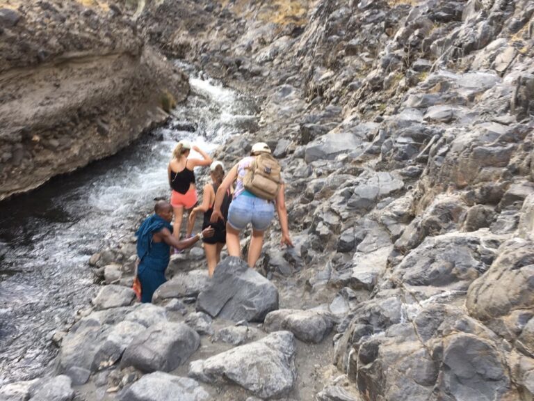 klauterende mensen op een rotsachtig pag bij de ngare sero rivier