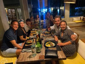 10 gasten van droomreis tanzania aan een lange tafel tijdens een diner gemaakt door hun eigen privé kok op het eiland zanzibar