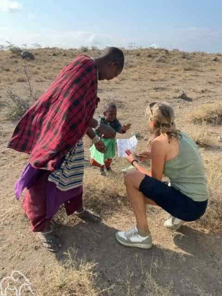 Reiservaring van gasten van Droomreis Tanzania. Vrouw met een Masai kindje en een Masai vrouw die in gesprek zijn