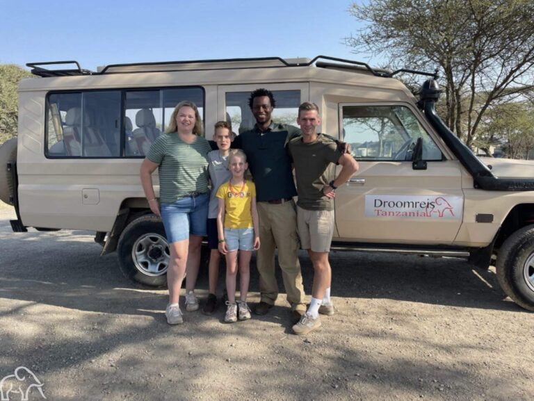 Reizigers met hun gids bij de safariauto