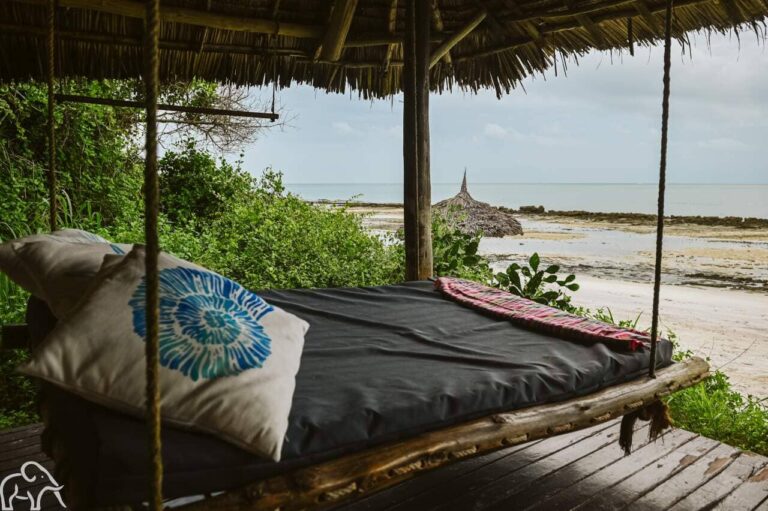 Hangend ligbed op de veranda van een strandaccommodatie met uitzicht op de Indische Oceaan in Tanzania.
