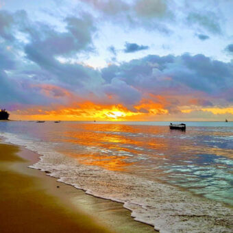 zonsondergang oranje gekleurde zee en wolken afgewisseld met blauwe wolken bij Pangani tijdens een zonsondergang