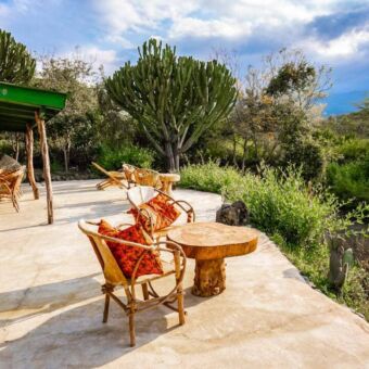 Twee stoelen op een veranda met uitzicht over Arusha National Park