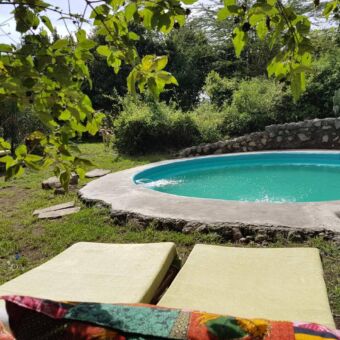 Twee ligbedden bij het zwembad van hillside accommodatie