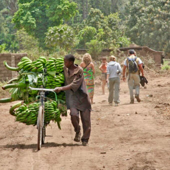 bananen transport nabij Mto-wa-Mbu onverharde weg met lopende man en fiets volste bananen trossen in Mto wa Mbu