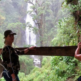 Materuni waterval vrouw met petje vanaf een uitzichtpunt op de materuni waterval tanzania