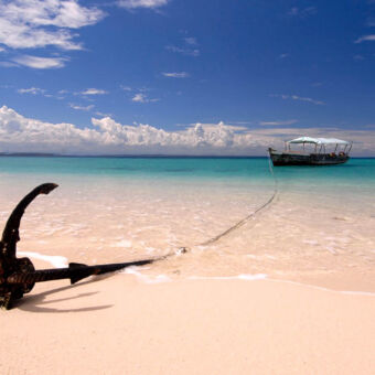 geweldige kleuren vanaf het anker in het zand kijkend naar een oude boot met afdak liggend in een azuurblauwe indische oceaan bij pangani tanzania