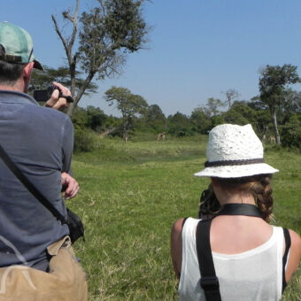 wandelsafari in tanzania: te voet dieren spotten wandelsafari in tanzania met een man en jong meisje met camera's zijn dieren aan het spotten en fotograferen