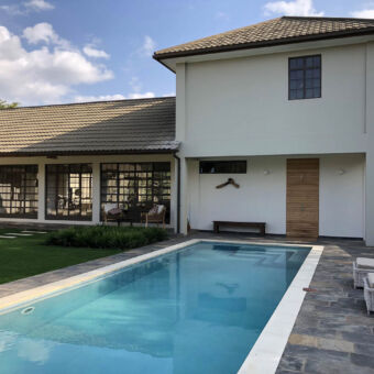 privé met je eigen reisgezelschap rechthoekig zwembad met witte villa en veel ramen voor 10 personen in de buurt van arusha