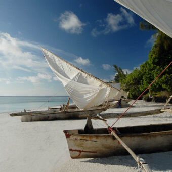 strand met dhows twee dhows op het strand met de zeilen half neer gebreken aan de rand van de indische oceaan op pemba tanzania