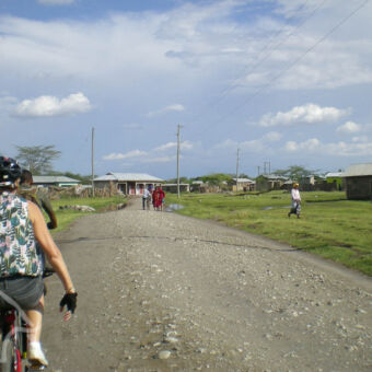 bekijk het dagelijkse leven 2 mensen op een mountainbike fietsend door een dorpje bij mto wa mbu tanzania