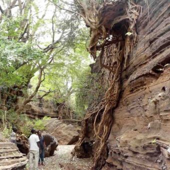 indrukwekkende landschappen 3 mensen die omhoogkijken naar een rots tijdens het wandelen van de canyon walk bij lake chala tanzania