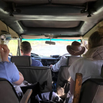 gasten in een safariauto onderweg met de gids achter het stuur