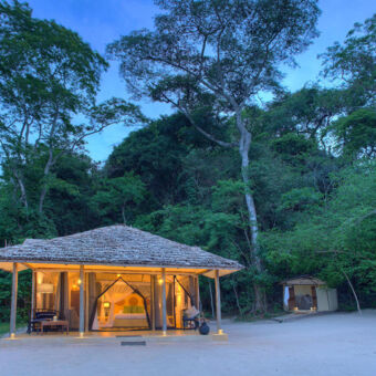 prachtige romantische accommodatie luxe tent met rieten dak verlicht op het strand van lake victoria rebondi tanzania luxe privé safari