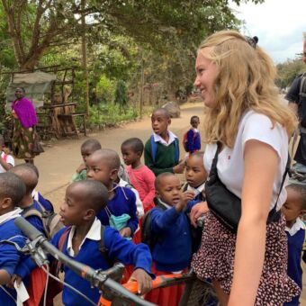 meisje staand met mountainbike tussen kleine tanzaniaanse kinderen activiteit tanzania