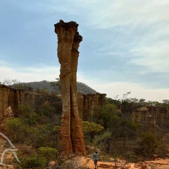zeer hoge pilaar bij isimilia stone age met een persoon er voor
