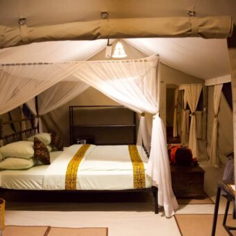 mooi opgemaakt bed met witte lakens in een tented camp bij tortilles tarangire tanzania