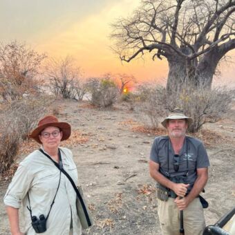 vrouw in safarikledingen en gids met geweer tijdens een wandelsafari in ruaha national park tanzania