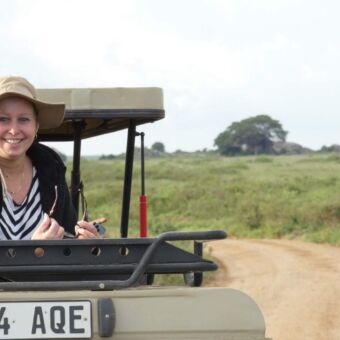vrouwelijke gast van droomreis tanzania in een safari auto met open dak tijdens een gamedrive