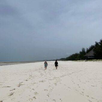 twee mensen die overeen wit strand lopen van de indische oceaan op zanzibar