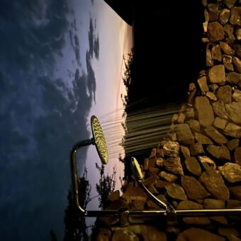 buitendouche bij lahia tented camp op de serengeti. de douche is ommuurt uit losse stenen en je hebt uitzicht over de serengeti