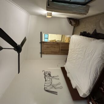 in een kamer van arusha villa waar een groot bed staat en aan de witte want zie een grote gnoe gemaakt van draadstaal