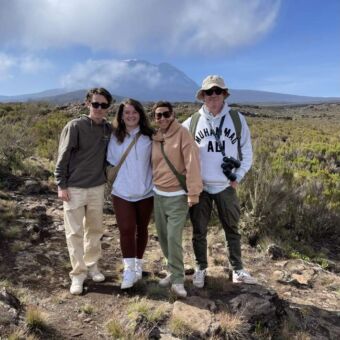 Vier mensen tijdens een hike naar het Shira plateau. oude achtergrond de top van Mount Kilimanjaro