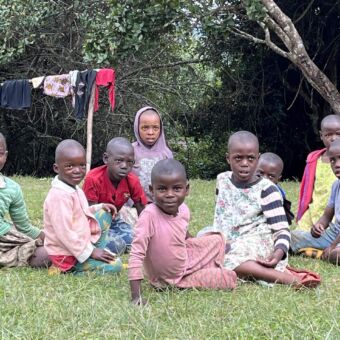 groepje Tanzaniaanse kinderen die in het gras zitten. sommige lachend anderen kijken een beetje verbaast. In de buurt van Mufindi highlands Tanzania