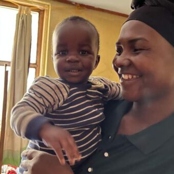 tanzaniaanse vrouw met haar zoontje op de arm. Ze liggen allebei