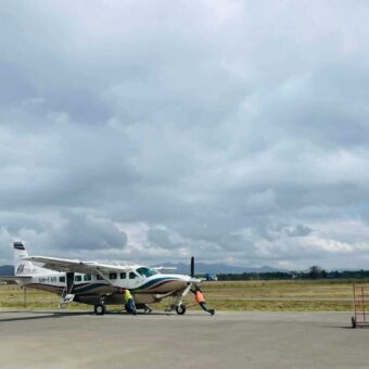 Op Arusha airport zijn twee mensen een klein vliegtuigje aan het verplaatsen en klaar maken voor de volgende vlucht