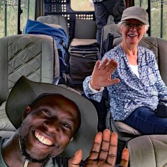 Reiservaring safari Tanzania. Selfie van gids in de safariauto met een vrouwelijke gast achterin tijdens een gamedrive