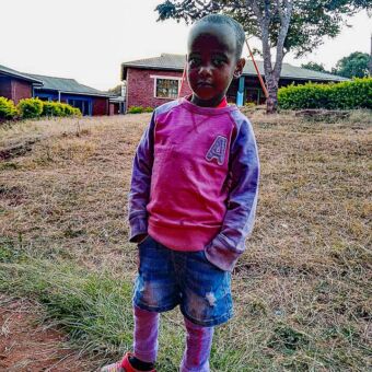 Resiverslag individuele rondreis Tanzania. Klein meisje die lief lacht en staat in de buurt van Rhotia Valley.