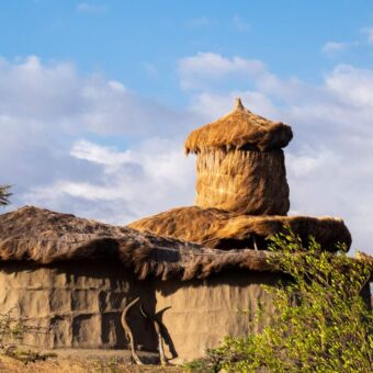 Accommodatie Masai lodge in de buur van de Kilimanjaro. De huisjes zijn traditionele Masai huizen. Donkergrijs maar voorzien van alle luxe. Review Tanzania