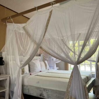 Accommodatie Arusha Tanzania. Een mooi opgemaakt bed met een klamboe